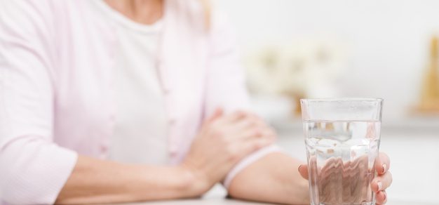 close-up-mature-woman-holding-glass-water_23-2148440110