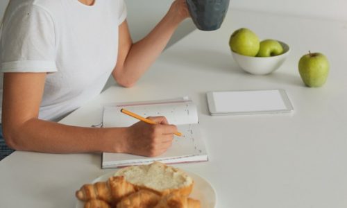 close-up-woman-planning-her-day-keeps-grey-cup-with-some-liquid_295783-372